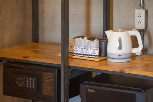um balcão com um micro-ondas e comodidades para preparar café em EcoLoft Hotel - SHA Plus em Cidade Phuket