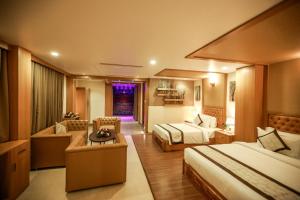 ein Hotelzimmer mit 2 Betten und einem Sofa in der Unterkunft Nesma Palace in Kannur