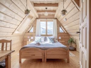 コシチェリスコにあるWierchowa Chataの木製の部屋にベッド1台が備わるベッドルーム1室があります。
