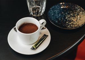 una taza de café en un plato con un cigarrillo en ProfilHotels Nacka, en Estocolmo