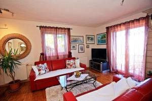 a living room with a red couch and a tv at Holiday Home with Pool (4298) in Kučište