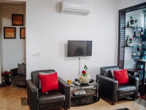 a living room with two chairs and a tv at Stunning 2-Bed Apartment in Dar es Salaam in Dar es Salaam
