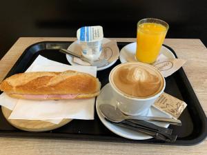 Hotel BESTPRICE Girona في جيرونا: صينية مع ساندويتش وكوب من القهوة