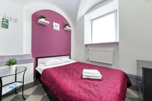 a bedroom with a purple bed and a table at Guest House Prosto in Saint Petersburg