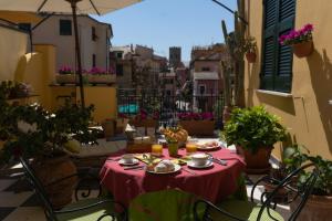 a table with food and drinks on a balcony at Locanda Il Maestrale in Monterosso al Mare