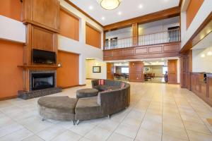 een grote lobby met een bank en een open haard bij La Quinta by Wyndham Longview North in Longview