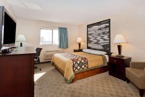 a hotel room with a bed and a television at Super 8 by Wyndham Rochelle in Rochelle