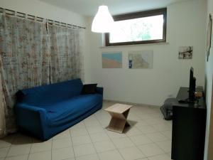 a living room with a blue couch and a window at Appartamento La Bonifica in Pescara