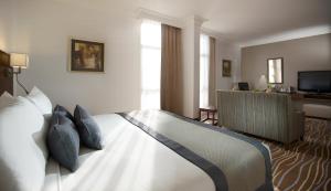 a hotel room with a bed and a television at Copthorne Downtown by Millennium in Abu Dhabi