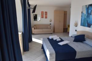 a bedroom with a blue bed and a couch at Hotel Profumo Di Mare in Otranto