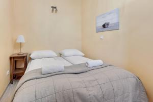 a bedroom with a bed with two pillows on it at Grand Apartments - Neptun Park. in Gdańsk