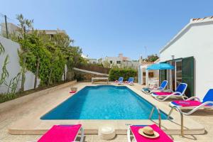 a swimming pool with lounge chairs and a swimming pool at Villa Romani Arenal by Villa Plus in Arenal d'en Castell
