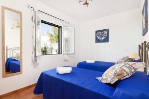 a bedroom with two blue beds and a window at Villa Romani Arenal by Villa Plus in Arenal d'en Castell +16 photos