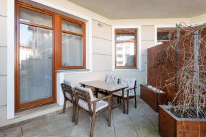 a patio with a table and chairs and a window at Grand Apartments - Neptun Park. in Gdańsk