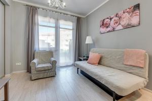 a living room with a couch and a chair at Grand Apartments - Neptun Park. in Gdańsk