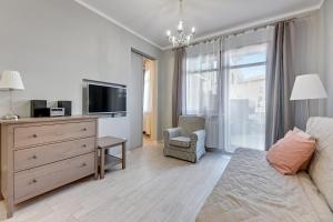 a living room with a couch and a tv and a dresser at Grand Apartments - Neptun Park. in Gdańsk