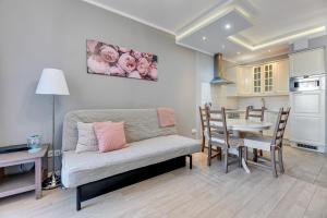a living room with a couch and a table at Grand Apartments - Neptun Park. in Gdańsk