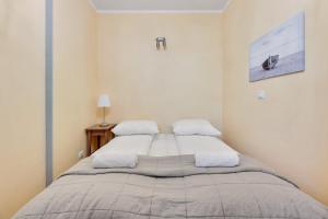 a bedroom with a large bed with two pillows at Grand Apartments - Neptun Park. in Gdańsk