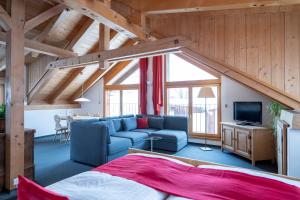 a living room with a blue couch and a tv at Hotel Engiadina in Scuol