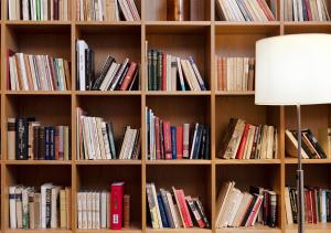 
a bookcase filled with books on top of a wooden shelf at ProfilHotels Riddargatan in Stockholm
