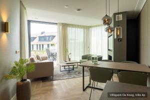 a living room with a table and a dining room at Villapark De Koog in De Koog