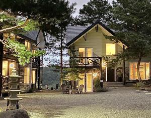 a house with chairs and tables in front of it at Furano Lofts in Furano