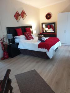 1 dormitorio con 1 cama grande con almohadas rojas en Christa's Place 897 en Pretoria