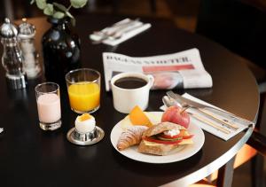 a table with a plate of breakfast food and a newspaper at ProfilHotels Riddargatan in Stockholm