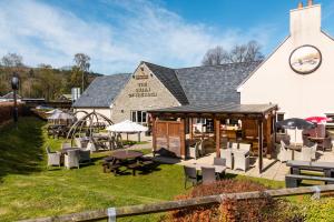a building with tables and chairs in front of it at Queen of the Loch, Balloch by Marston's Inns in Balloch
