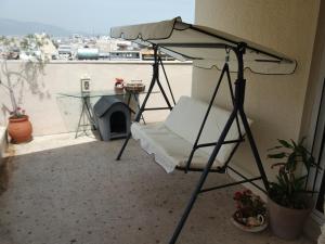 einen Stuhl unter einem Schirm auf einem Balkon in der Unterkunft EXCELLENT SUNNY APARTMENTS!enjoy yourRELAXwithVIEW in Athen