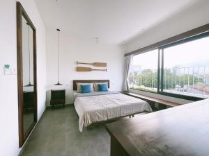 sypialnia z łóżkiem i dużym oknem w obiekcie NGÔ Homestay Phan Thiết w mieście Ấp Bình Hưng