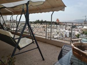 uma cadeira debaixo de um guarda-chuva numa varanda em EXCELLENT SUNNY APARTMENTS!enjoy yourRELAXwithVIEW em Atenas