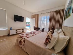 um quarto de hotel com uma cama e uma televisão em Hotel Santa Clara Doradal em Doradal