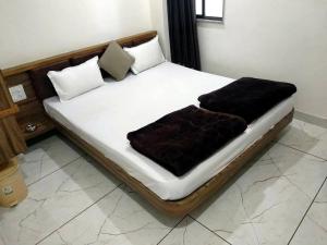 a bed with two pillows on it in a room at Hotel Milan in Ahmedabad