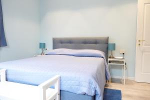 ein Schlafzimmer mit einem großen Bett mit einer blauen Decke in der Unterkunft Meuble' 21 di Anna in Reggio nell'Emilia