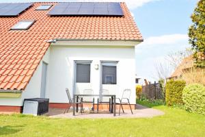 una casa con paneles solares en el techo en DEB 041 Ferienwohnung am Kurpark A, en Altefähr