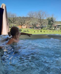a young girl is in a hot tub at Gîtes Les Nogalies SPA PRIVATIF in Valojoulx