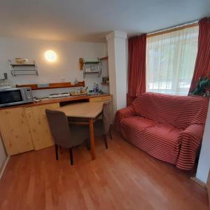ein Wohnzimmer mit einem Tisch und einem Sofa in der Unterkunft Apartamente Casa Cristina in Pensiune la 400m de Pârtia de ski in Buşteni