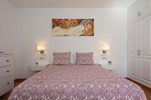 a bedroom with a bed and a painting on the wall at Apartment Fragata in Playa Honda