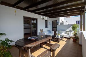 a living room with a wooden table and benches at Apartment Fragata in Playa Honda