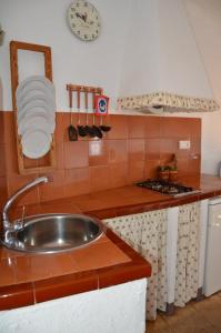 eine Küche mit einem Waschbecken und einer Uhr an der Wand in der Unterkunft RCP El Racó in Pacs del Penedes