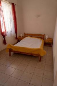 Un dormitorio con una cama con una manta amarilla. en Gîte La Place en Fosse