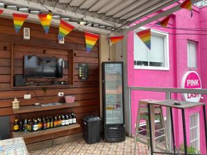 a pink building with a tv and a bar at Did's Hostel São Paulo in São Paulo
