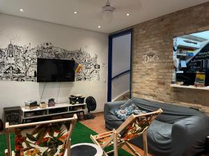 a living room with a couch and a tv at Did's Hostel São Paulo in Sao Paulo