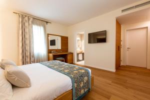 a hotel room with a bed and a television at Relais Althea Azienda Agrituristica in Vittorio Veneto +90 photos
