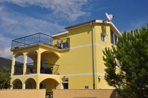 a yellow building with a balcony on top of it at Apartments Villa-G Lustica in Tivat