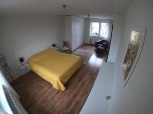 a bedroom with a bed with a yellow blanket at Apartament Magdaleentje in Gdańsk