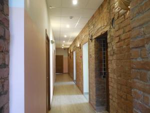a corridor of an office with a brick wall at Gogol Park Rooms in Rīga