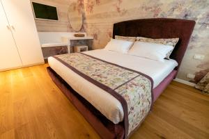 een slaapkamer met een groot bed met een houten hoofdeinde bij Relais Althea Azienda Agrituristica in Vittorio Veneto