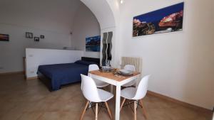 sypialnia z łóżkiem, stołem i krzesłami w obiekcie Piazza grande w mieście Polignano a Mare